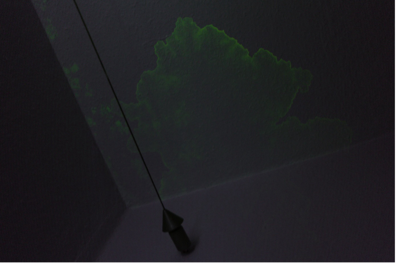 Bild zeigt dunkles zimmer mit grün floureszierenden Verfärbungen